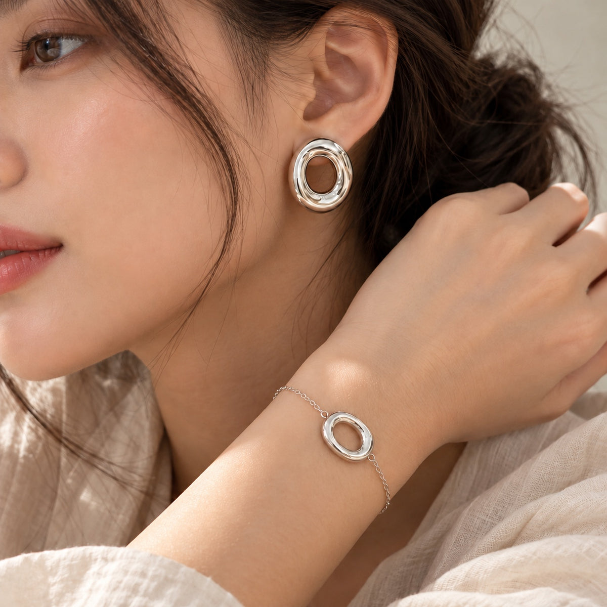 Modelo con conjunto de pendientes y pulsera plateados