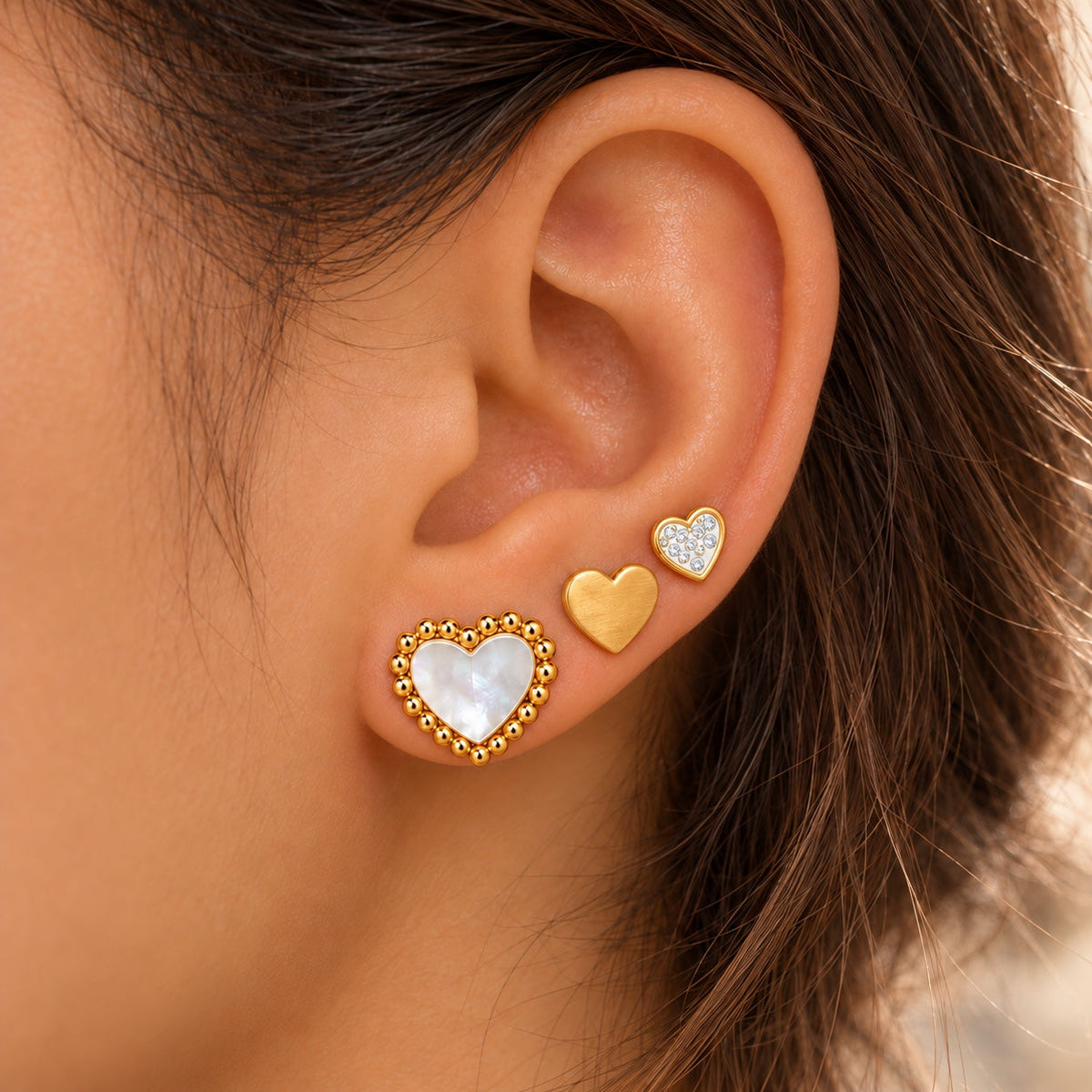 Pack Tres Corazones dorados, 3 pares de pendientes de acero inoxidable puestos en la oreja