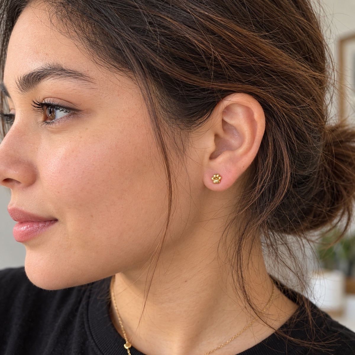 Pendientes huella de perrito dorados en modelo