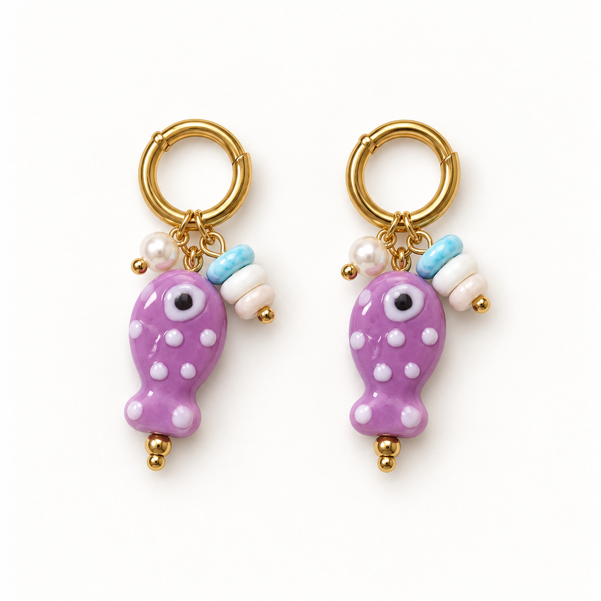 Par de pendientes dorados con pez lavanda y cuentas decorativas
