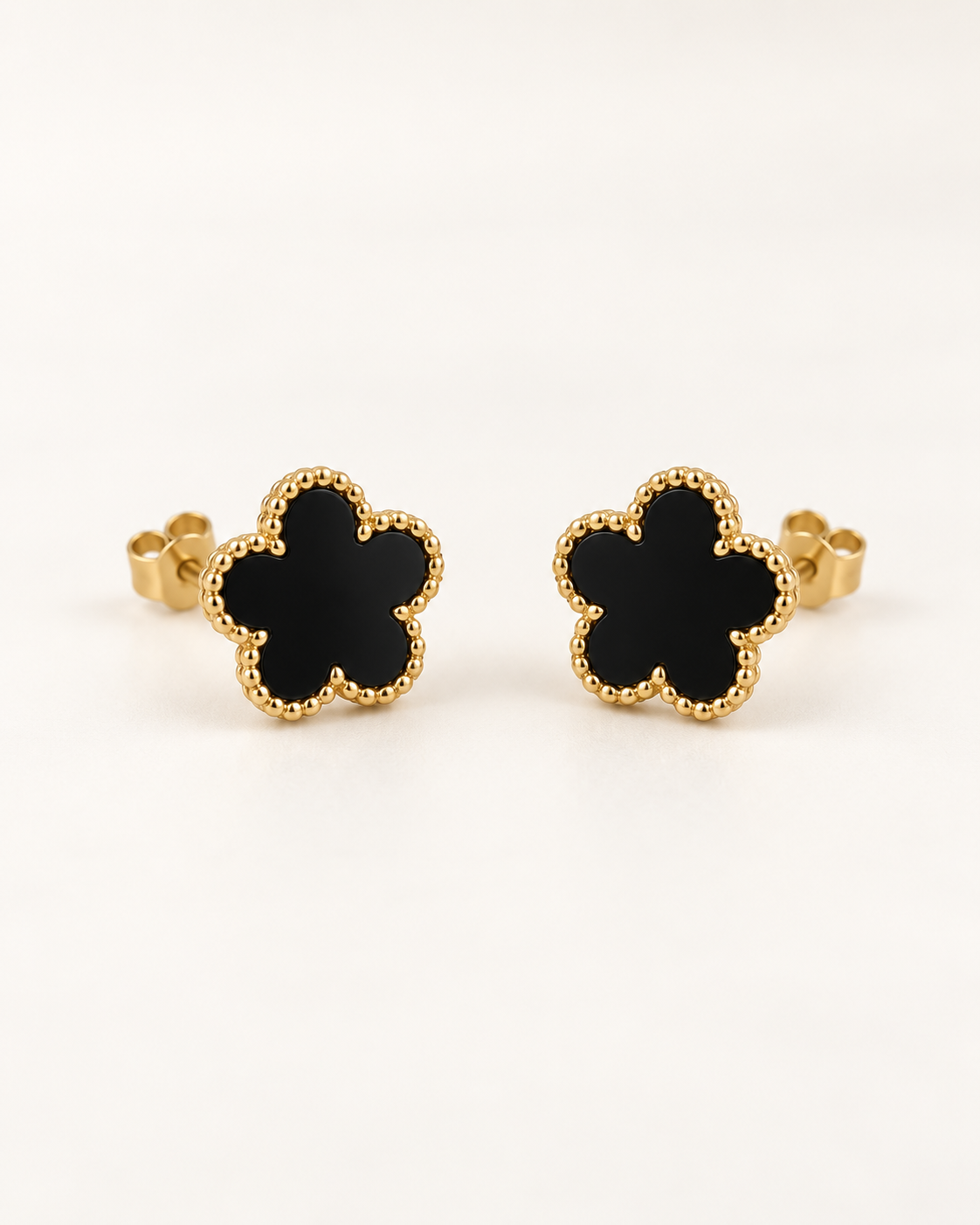 Par de pendientes negros de cinco puntas con contorno dorado