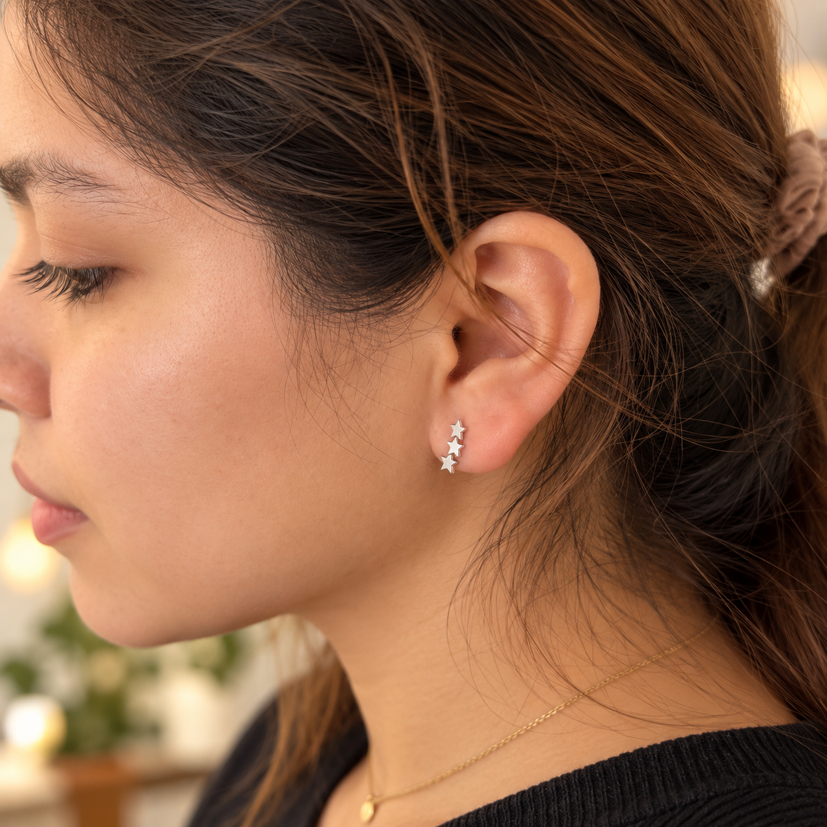 Pendientes tres estrellas plateadas en modelo