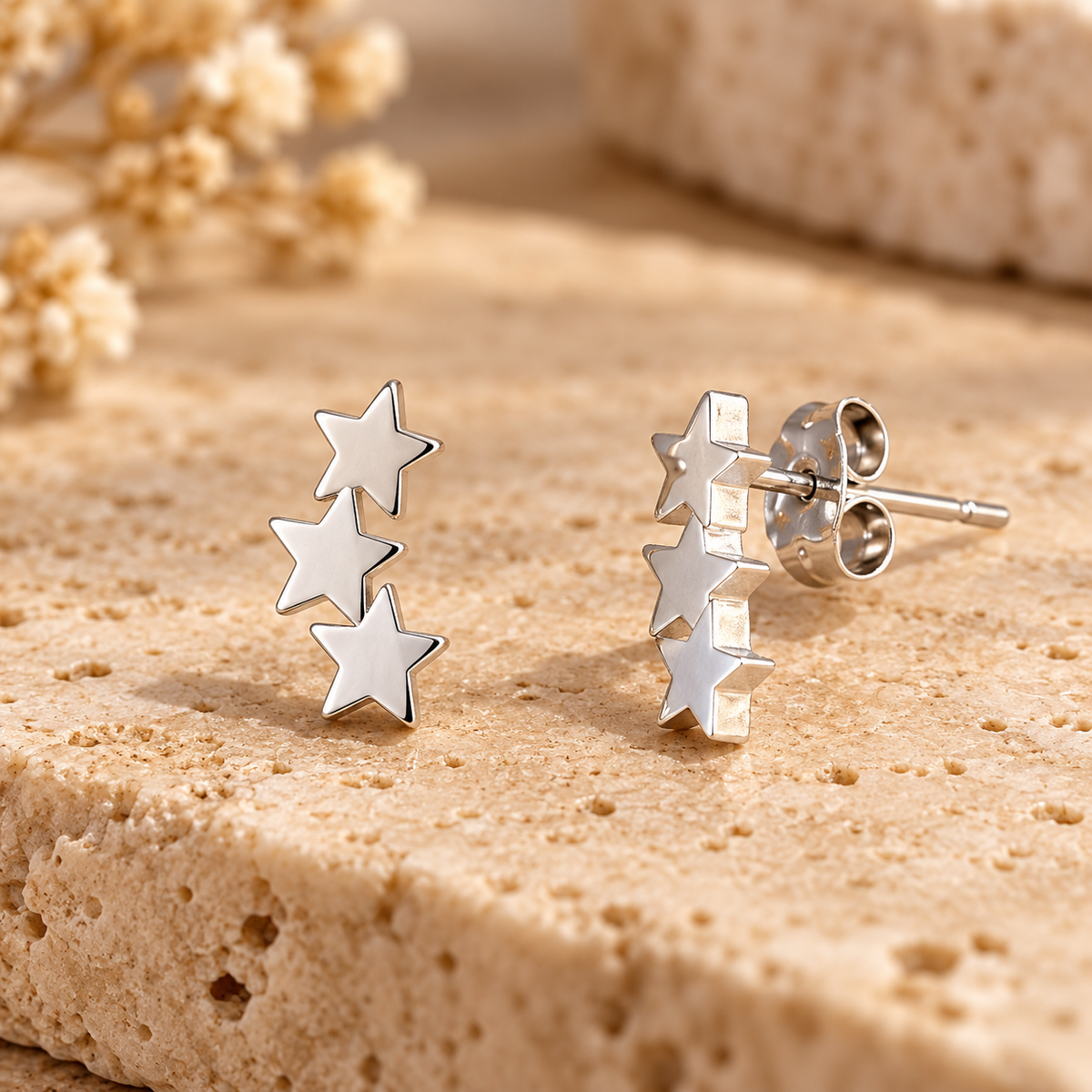 Pendientes tres estrellas plateadas vista lateral