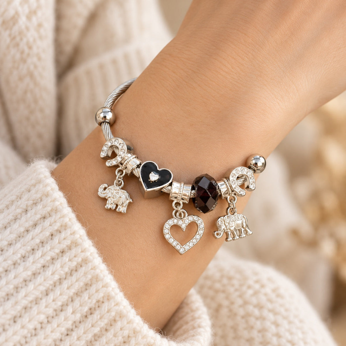 Pulsera negra con elefantes y corazón en muñeca
